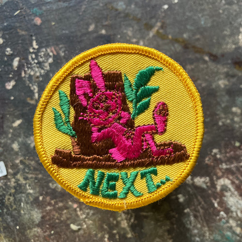 Vintage pink rabbit patch with the word NEXT written below. This suggestive retro patch is for sale on our website!