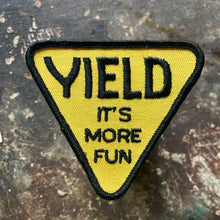 Vintage suggestive patch that reads Yield It's More Fun written on it.